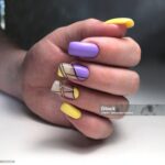 Multicolored manicure close up. Young woman hands with pastel manicure